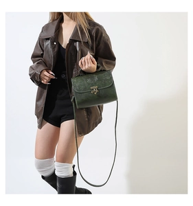 Détail du sac bandoulière vintage vert foncé avec rabat gaufré et fermoir en bronze