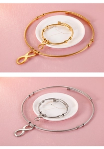 Detail of gold and silver infinity symbol necklace and bracelet set on pink texture