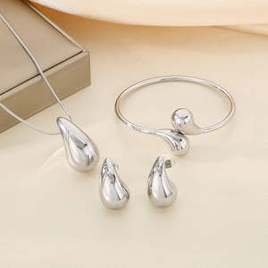 Detailed view of polished silver waterdrop jewelry set with necklace, bracelet and earrings