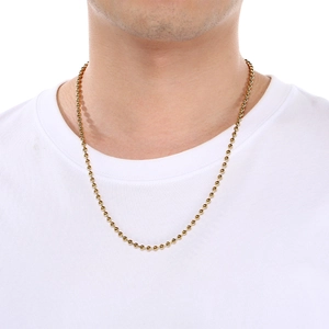 Collier minimaliste en chaîne à billes plaqué or 18 carats porté sur un t-shirt blanc