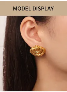 Detail of hammered gold fan earrings on model showing textured vintage finish