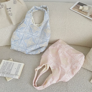 Detail of light blue and pink tote bags with exquisite 3D butterfly floral embroidery
