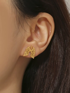 Macro shot of gold lung-shaped stud earrings featuring a hollow medical design on the ear