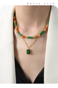 Dettaglio di una collana vintage a strati con pietre verdi e ciondolo smeraldo