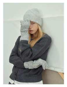 Close-up of model wearing grey wool blend knit gloves and matching beanie hat in winter
