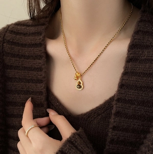 Detail of 18K gold plated gourd necklace with black stone and cubic zirconia inlay