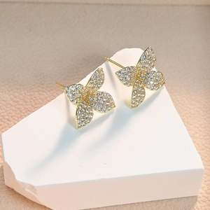 Elegant gold butterfly stud earrings inlaid with AAA cubic zirconia on a white stone base