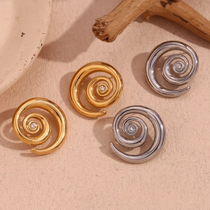 Detail view of J-shape wave earrings in gold and silver finish with crystal center
