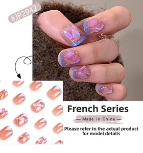 Détail de faux ongles French bleus avec accents de cristaux 3D sur une base rose nude