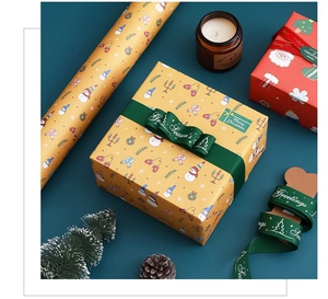 Detail of Christmas gift wrapping set with snowman paper, green ribbon and festive decor