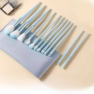 Detail of 12-piece mini makeup brush set with blue gradient bristles and storage bag