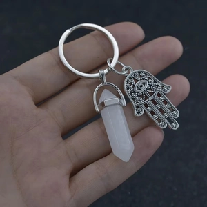 Macro view of Hamsa Hand and hex crystal pendant on a silver metal keychain