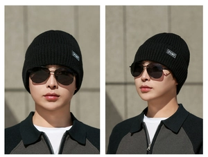 Close-up of black ribbed knit beanie featuring a premium FUMY stitched patch detail