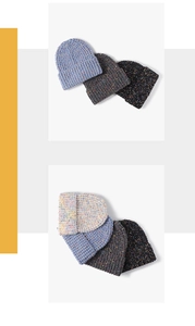 Detailed knit texture of colorful thick winter beanies featuring warm rolled-up brims