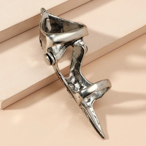 Macro detail of a silver gothic claw ring with mechanical armor design on a stone stand