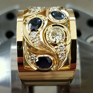Macro de la bague large ajourée sertie de saphirs bleus ovales et diamants sur or