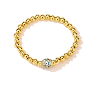 Macro detail of 18K gold plated bead bracelet with blue evil eye and sparkling zircon