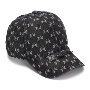 Close-up of distressed denim baseball cap with butterfly print and vintage ripped brim