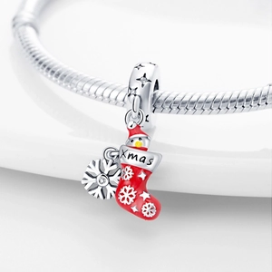 Close-up of silver Christmas stocking and snowflake charms with red enamel and Xmas engraving