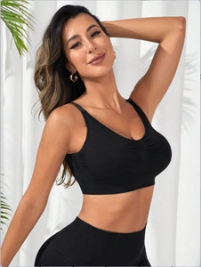 Detail of black seamless high-stretch sports bra with ruched front and wide underband support