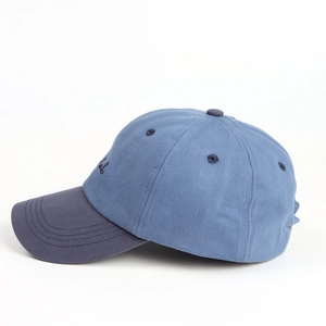 Vue détaillée d'une casquette en coton bleu clair avec visière marine et broderie latérale