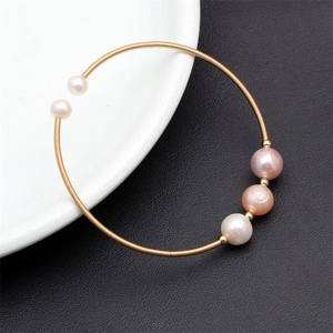 Detail of gold thin-wire bracelet with five colorful natural freshwater pearls