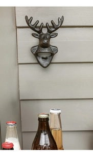 Detalle de abridor de botellas de pared en hierro fundido con forma de cabeza de alce