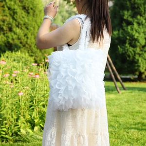 Detailed close-up of a white layered ruffle handbag featuring a sweet forest-inspired design