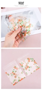 Detail view of floral self-adhesive treat bags with orange roses for cookies and candy