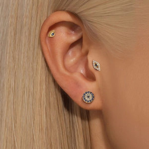 Detailed view of S925 silver devil eye earring set with blue stones on a model's ear