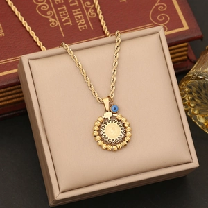 Detailed view of a gold rope chain necklace with a coin pendant and blue evil eye charm