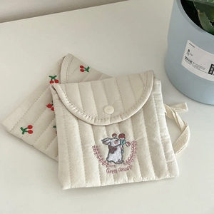 Detail of quilted beige sanitary pads bag with cute rabbit embroidery and cherry pattern