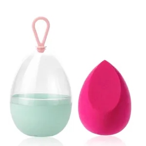 Rozerode make-up spons in muntgroene opbergdoos met roze siliconen draagkoordje