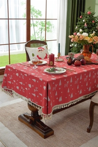Close-up of red Christmas tablecloth with elk patterns and elegant fringe tassels