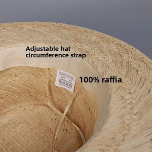 Detail view of the inner raffia hat crown featuring an adjustable strap and washing label