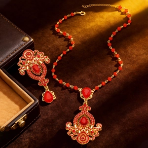 Macro shot of luxury vintage gold necklace and red crystal earrings on brown velvet