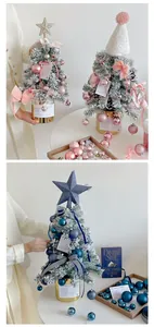Close-up of mini flocked Christmas tree with pink ornaments and golden base