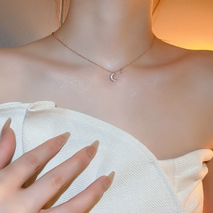 Gros plan du collier choker lune en or rose avec nacre blanche sur le cou du mannequin