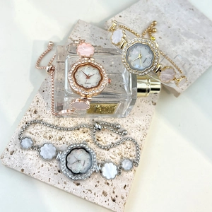 Detailed view of women's quartz watches with floral rhinestone bezels and pull-chains