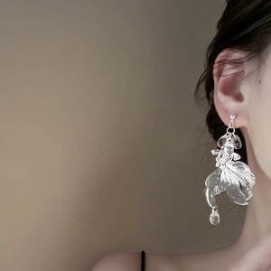 Artistic silver koi fish earrings with hollow metal texture and clear teardrop beads