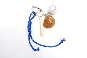 Detail of baseball keychain with white mini ball, brown leather glove and wooden bat