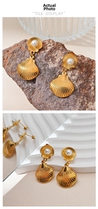 Close-up of golden shell earrings with freshwater pearls displayed on natural brown rock