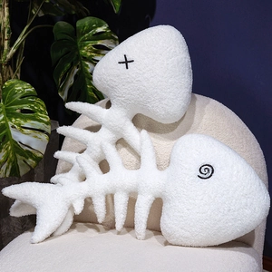 Cartoon fish bone plush pillows set with embroidery on a stylish chair with plants