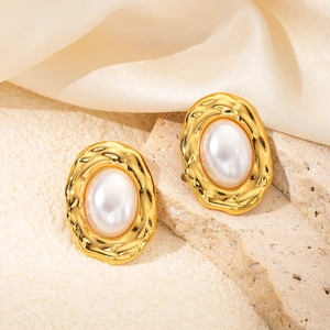 Detailed shot of vintage French style gold flower earrings with pearls on stone