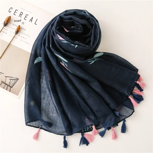 Detail of navy blue floral scarf with elegant pink and blue tassels on white background