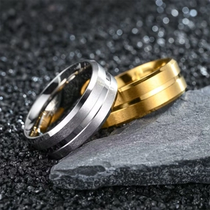 Minimalist titanium steel ring for men in gold and silver finish on volcanic stone background