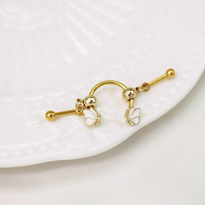 Makroaufnahme von Schmetterling-Industrial-Piercing mit Gold-Finish und weißer Emaillierung