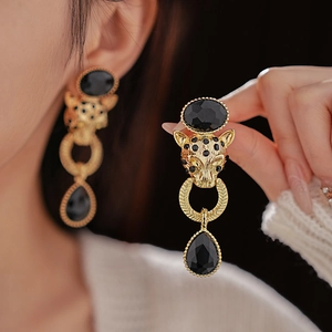 Detail of vintage leopard head earring with gold plating and black teardrop gem