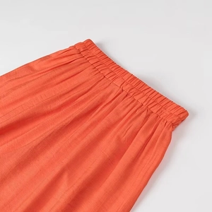 Vue détaillée de la taille élastique orange sur le pantalon de vacances en lin