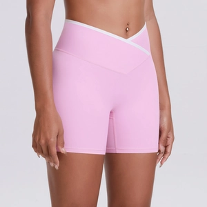 Detail of pink yoga shorts featuring a criss-cross high waist and white contrast binding